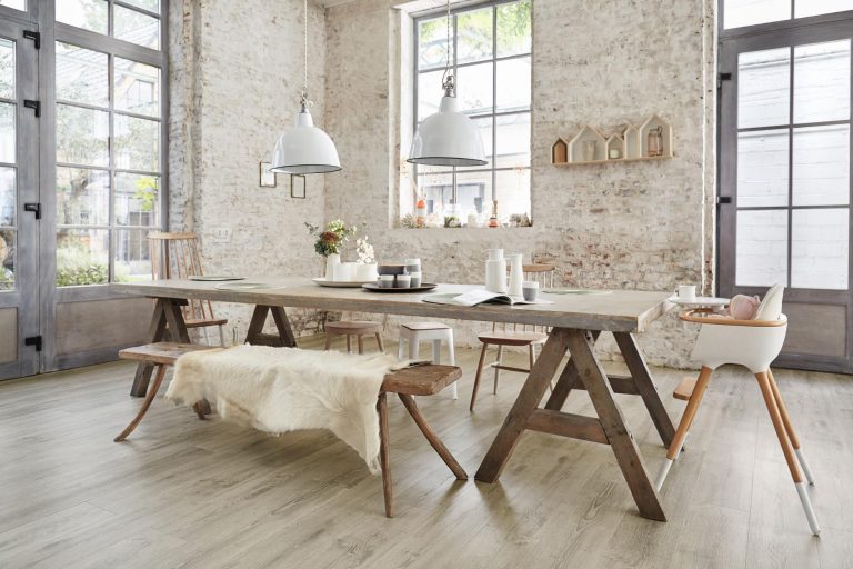 Ein Esszimmer mit einem Holztisch und Stühlen sowie elegantem Vinylboden. Thomas Jung Maler- & Stukkateurbetrieb aus Spiesen