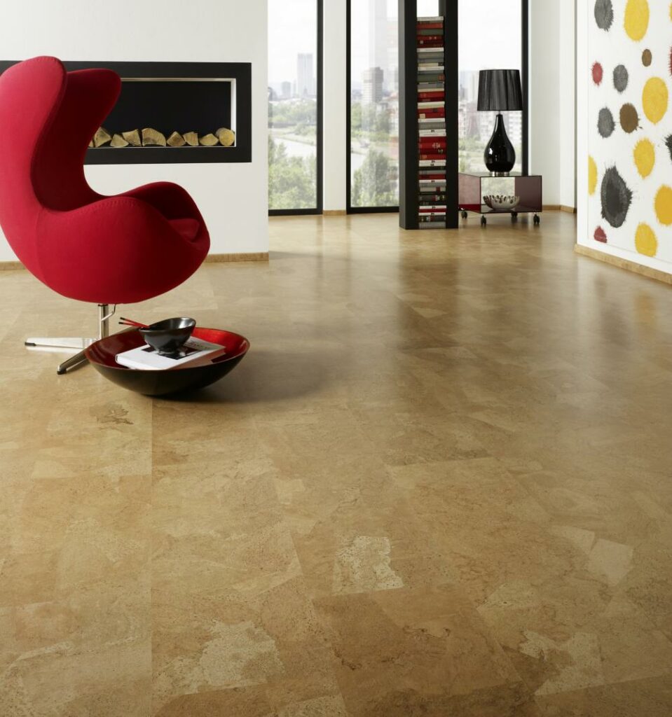 Ein Wohnzimmer mit einem roten Stuhl und einem Holzboden, in dem Malerarbeiten durchgeführt werden. Thomas Jung Maler- & Stukkateurbetrieb aus Spiesen