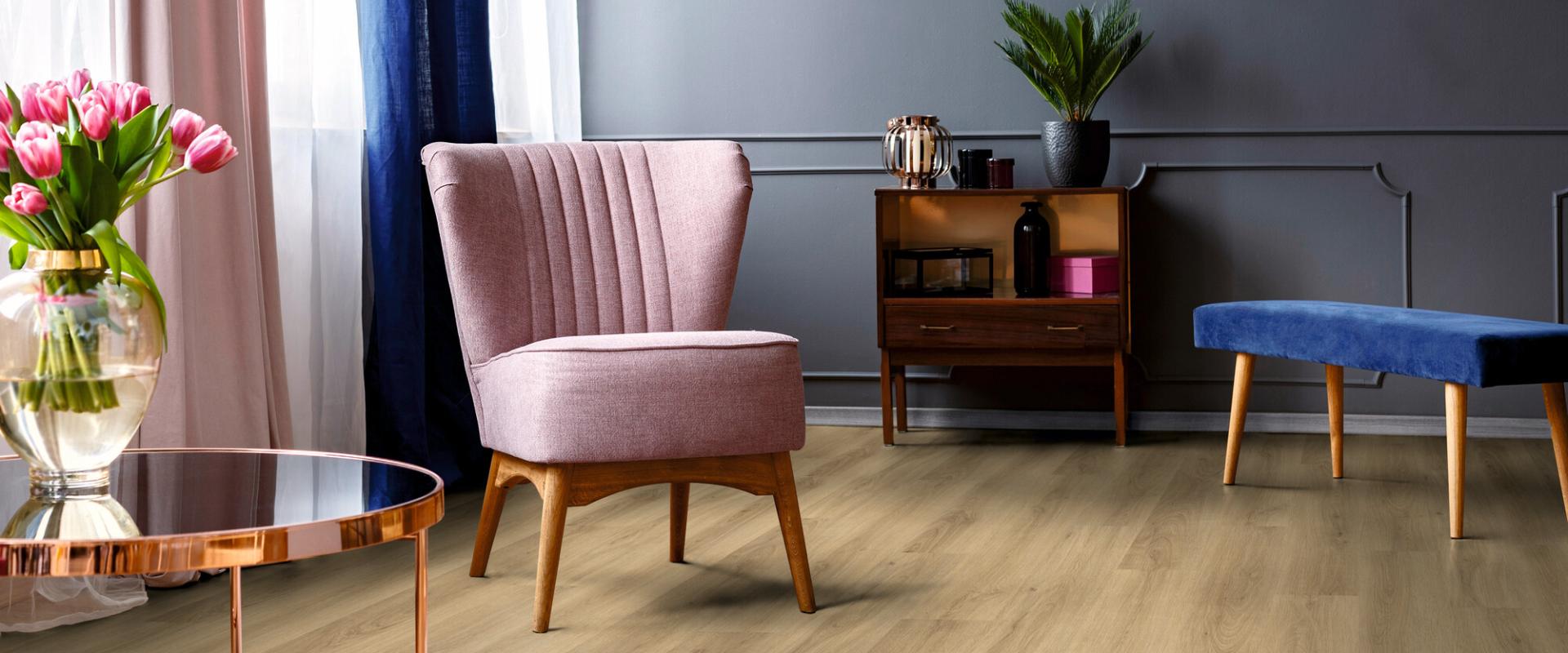 Ein Wohnzimmer mit Holzböden und einem rosa Stuhl, aufgewertet durch professionelle Malerarbeiten. Thomas Jung Maler- & Stukkateurbetrieb aus Spiesen